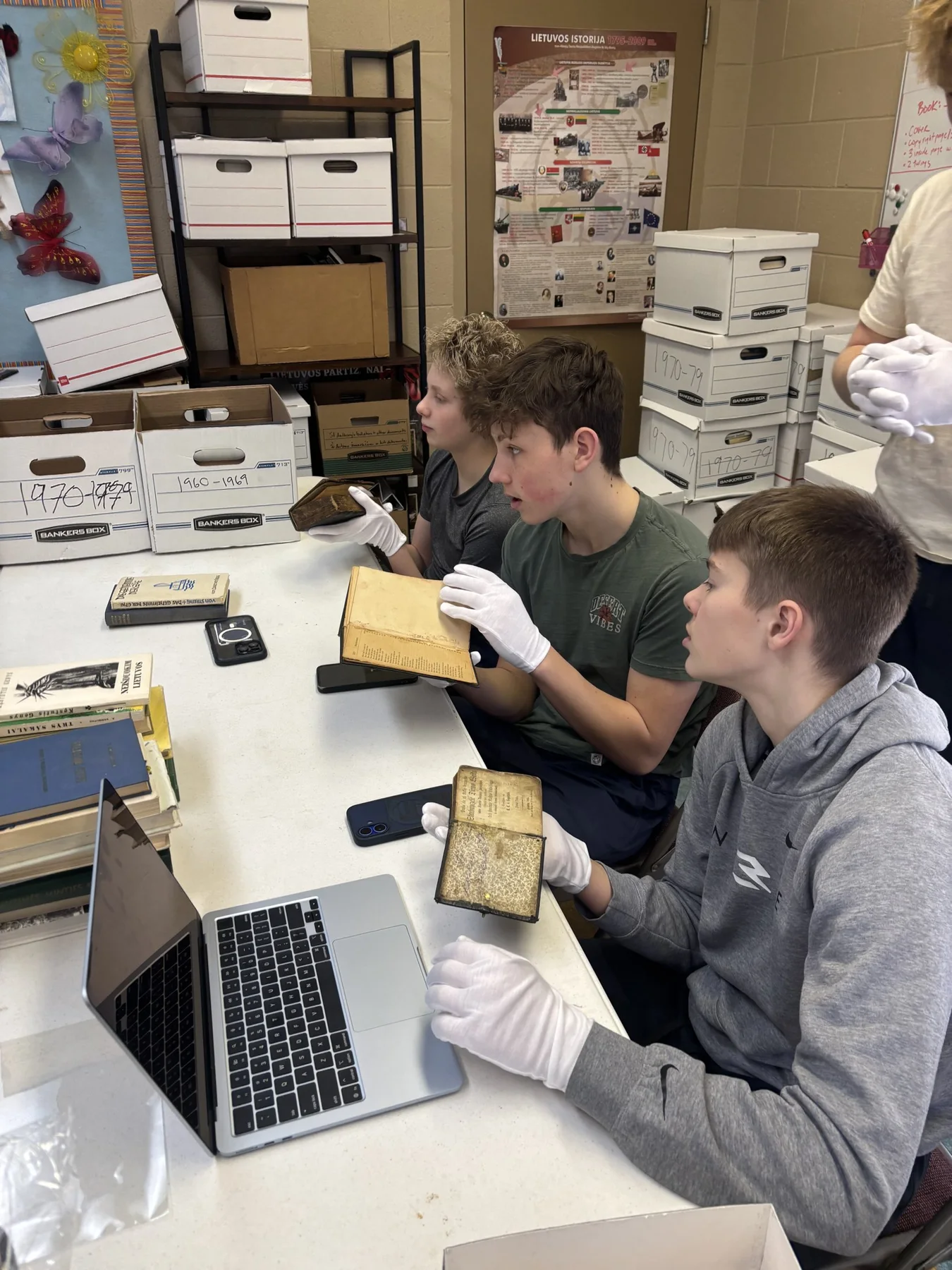Interns wearing gloves while examining some of the oldest books