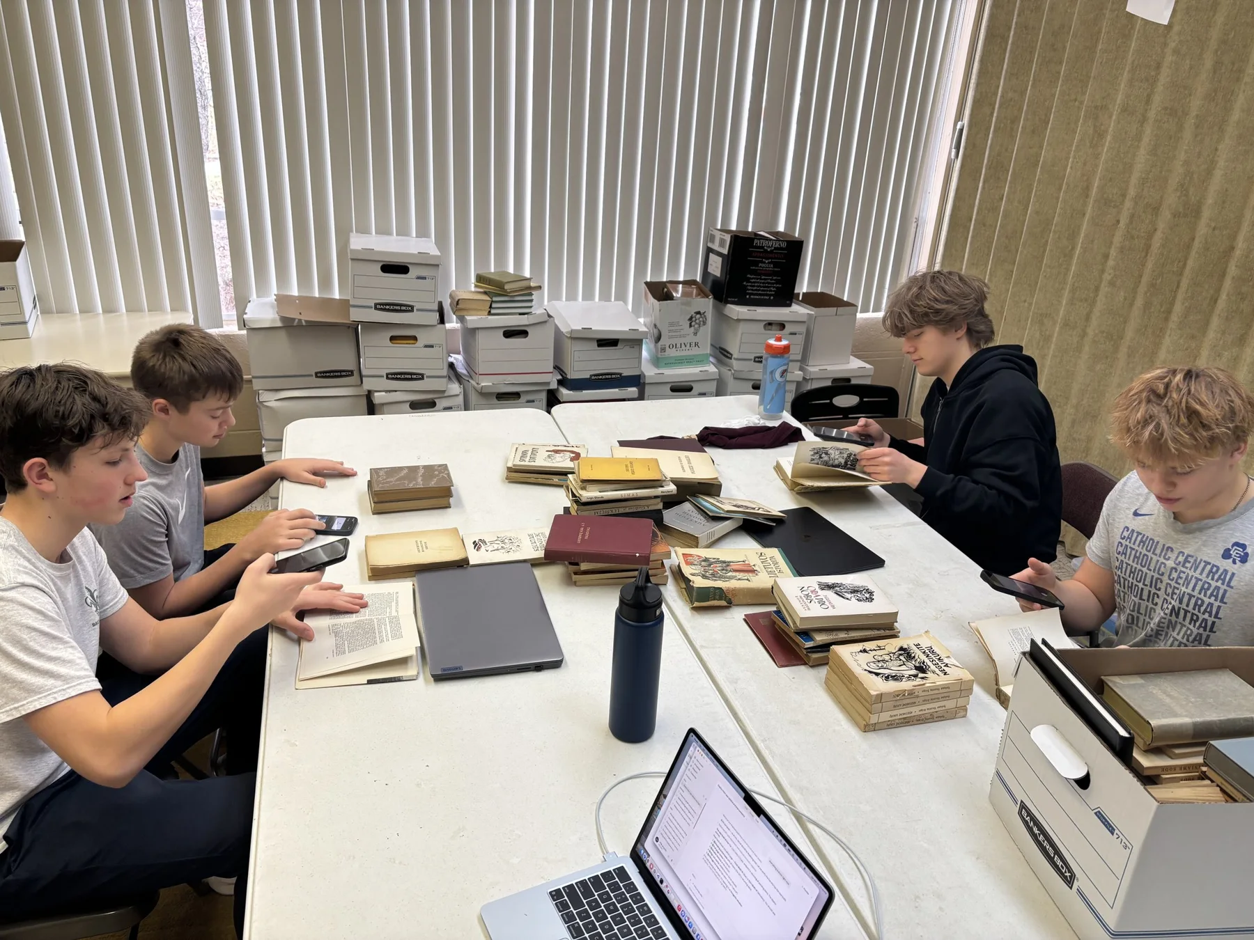 Interns photographing and checking publication details in books